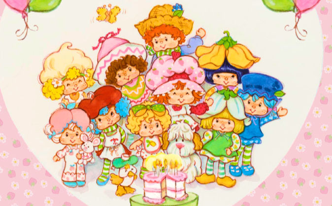 People gathered around a pink and white birthday cake